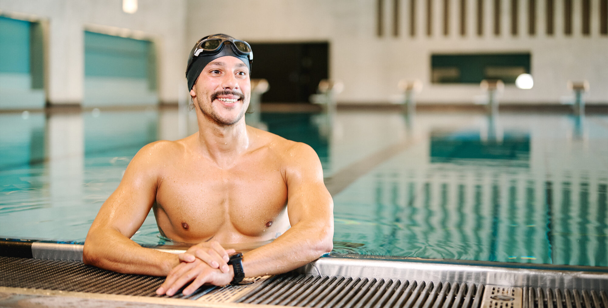 Schwimmer mit Schwimmbrille am Beckenrand